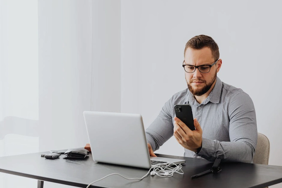 Profesionál soustředěně pracující na notebooku v moderní kanceláři.